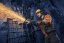Osoba v bezpečnostním vybavení používá úhlovou brusku k řezání kovových tyčí, čímž vznikají jiskry.